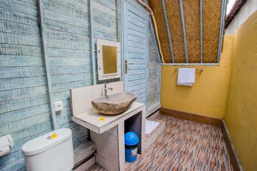 a bathroom with a sink and a toilet at D'Yuki Huts Lembongan in Nusa Lembongan