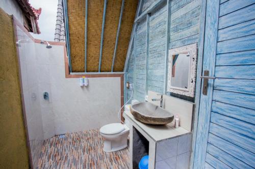 a bathroom with a sink and a toilet at D'Yuki Huts Lembongan in Nusa Lembongan