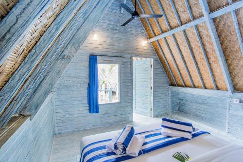 a bedroom with a bed in a room with a window at D'Yuki Huts Lembongan in Nusa Lembongan