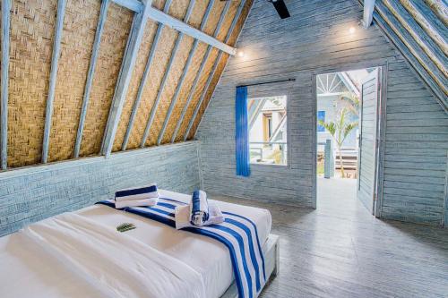 a bedroom with a large bed with towels on it at D'Yuki Huts Lembongan in Nusa Lembongan