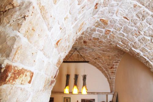 une arche dans un mur en pierre dans un restaurant dans l'établissement Camere Caroseno, à Castellana Grotte