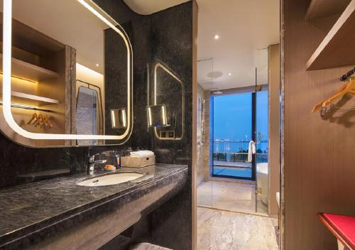 a bathroom with a sink and a large mirror at Grand Bay Hotel Zhuhai in Zhuhai