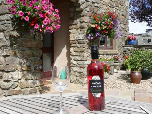 a bottle of wine and a glass on a table at Nutstile Farm Bed and Breakfast in Ingleton 