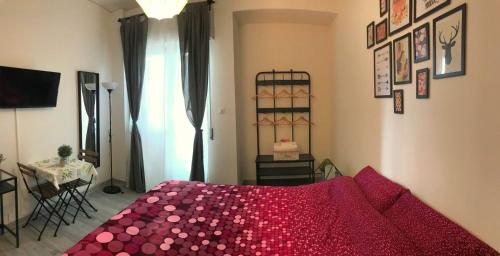 a bedroom with a bed with a red comforter at Mandala Bed & Breakfast in Viterbo