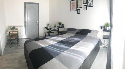 a bedroom with a black and white bed and a table at Mandala Bed & Breakfast in Viterbo