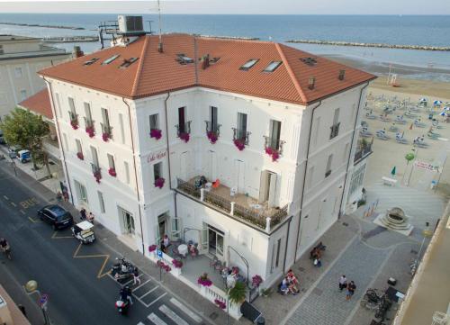 a large white building with a red roof on a street at Hotel Lido in Rimini