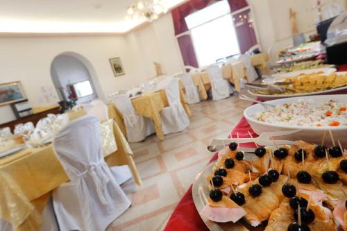 a room filled with tables with plates of food at Hotel Lido in Rimini