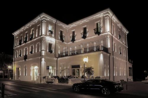a car parked in front of a building at night at Hotel Lido in Rimini