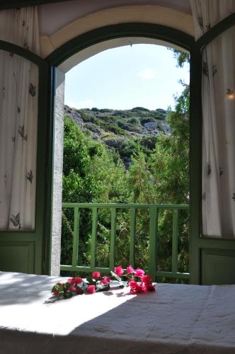 a bed with flowers on it in front of a window at Bellevue Apartments in Sitia
