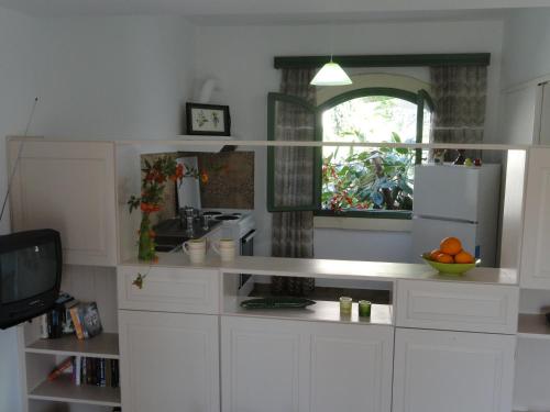 a kitchen with white cabinets and a mirror at Bellevue Apartments in Sitia