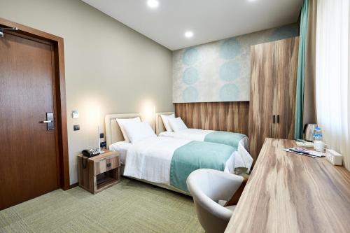 a hotel room with a large bed and a chair at Best Western Tbilisi City Center in Tbilisi City