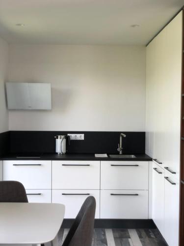 a kitchen with white cabinets and a sink at Utriai Guest Place in Utriai