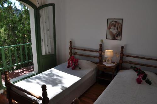 a bedroom with two beds and a large window at Bellevue Apartments in Sitia