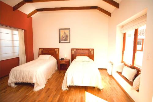 a bedroom with two beds and a window at Hotel Villa Antigua in Sucre