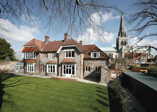 a large brick house with a church in the background at 4 Canon Lane in Chichester