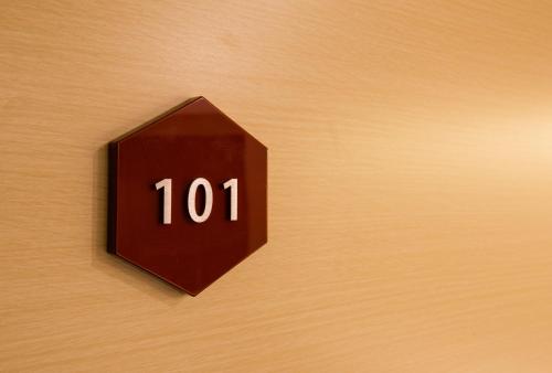 a brown clock with the number on a wall at Kyoto Kamanza Hotel in Kyoto