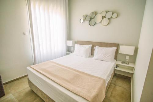 a bedroom with a large bed with white sheets and pillows at Teatro Deluxe Rooms in Kato Rodini