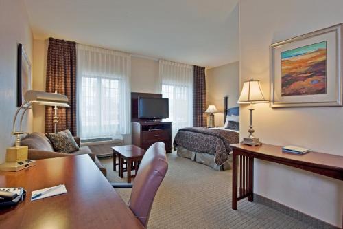 a hotel room with a bed and a living room at Staybridge Suites Tucson Airport by IHG in Tucson