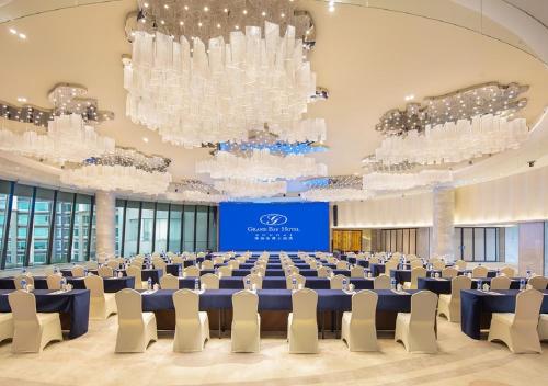 a large banquet hall with blue tables and white chairs at Grand Bay Hotel Zhuhai in Zhuhai