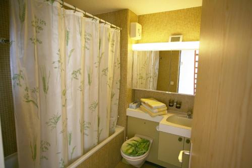 a bathroom with a shower curtain and a sink at I dr Rehwiesa A32 in Arosa