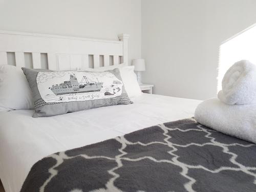 a bedroom with a bed with a pillow and a rug at Pearly Dunes in Pearly Beach