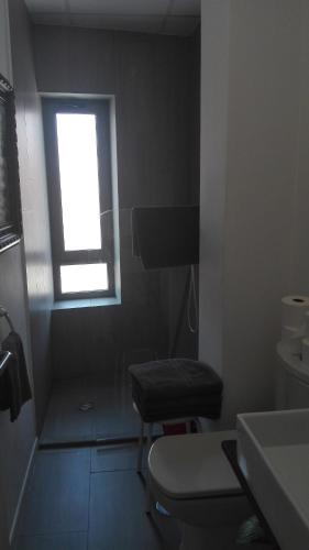 a bathroom with a window and a chair in it at TOLETUM low cost LOFTS diáfanos o 2dormitorios PARKING Municipal Gratis al aire libre a 100m in Toledo