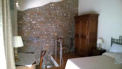 a bedroom with a brick wall and a bed at Antica Scuderia in Buttrio