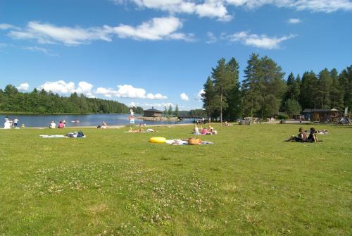 a group of people laying in the grass at a park at Rauhalahti Holiday Cottages in Kuopio