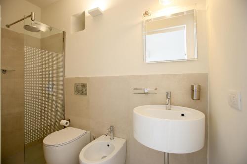 a bathroom with a sink and a toilet and a mirror at Suite mozart in Vieste