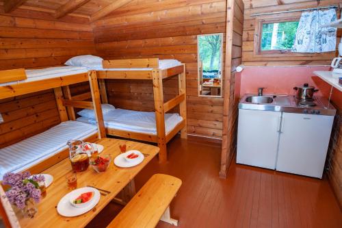 a room with bunk beds and a table in a cabin at Rauhalahti Holiday Cottages in Kuopio
