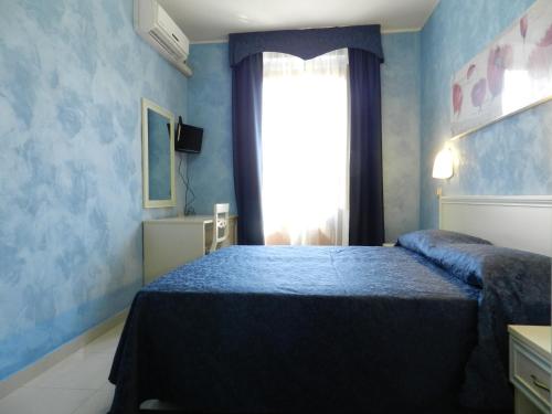 a blue bedroom with a bed and a window at Hotel Air Palace Lingotto in Turin