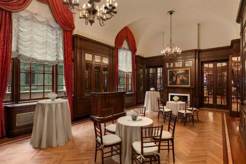 a dining room with tables and chairs and a chandelier at Fairmont Copley Plaza in Boston