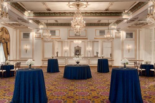 a ballroom with blue tables and chairs and a chandelier at Fairmont Copley Plaza in Boston