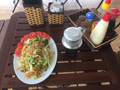 a plate of noodles and vegetables on a table at Sunshine Homestay in Phong Nha