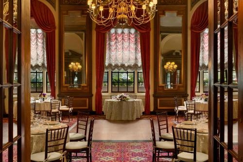 a dining room with tables and chairs and a chandelier at Fairmont Copley Plaza in Boston