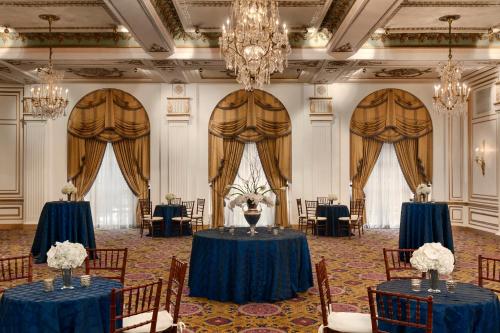 a banquet hall with blue tables and chairs and a chandelier at Fairmont Copley Plaza in Boston