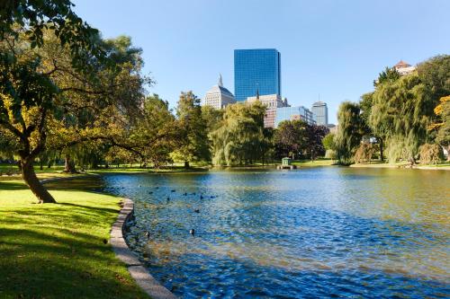 a park with a lake and a city in the background at Fairmont Copley Plaza in Boston