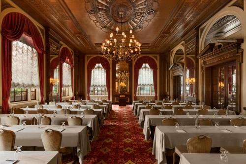 a large dining room with white tables and a chandelier at Fairmont Copley Plaza in Boston