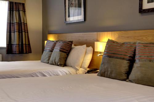 a hotel room with two beds and two lamps at Linton Lodge a BW Signature Collection Hotel in Oxford