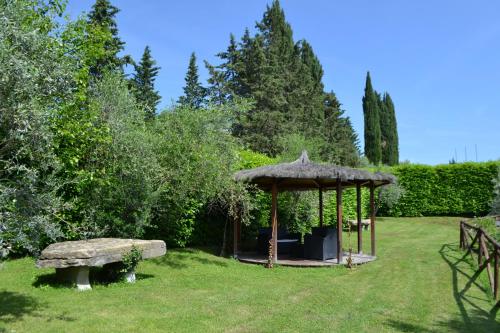a gazebo with a bench in a yard at Terre di Melazzano - Le Case di Chiara in Greve in Chianti