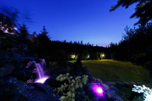 a waterfall at night with lights on the rocks at Hotel Helen in Bacău