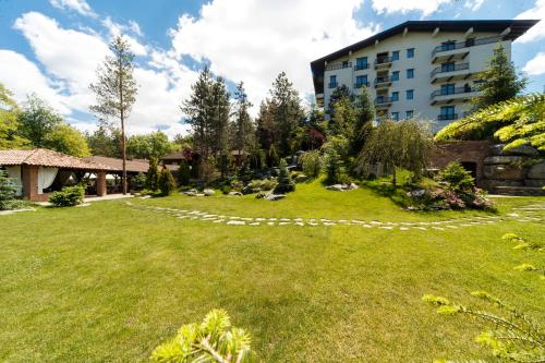 a garden in front of a building at Hotel Helen in Bacău