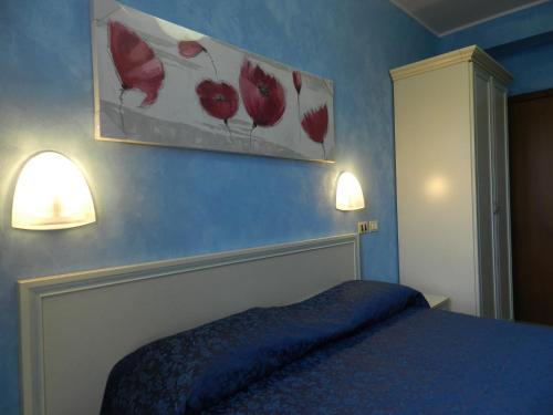 a bedroom with a bed and two lights on the wall at Hotel Air Palace Lingotto in Turin