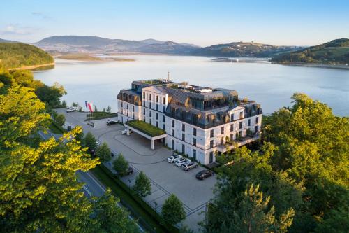 z góry widok na budynek nad jeziorem w obiekcie Heron Live Hotel Marina & SPA w mieście Gródek Nad Dunajcem