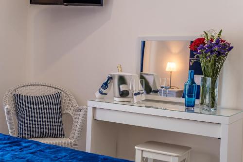 Habitación con mesa, espejo y flores en Suites @ Portarade, en Ferragudo