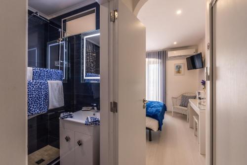a bathroom with a toilet and a sink and a mirror at Suites By The River in Ferragudo