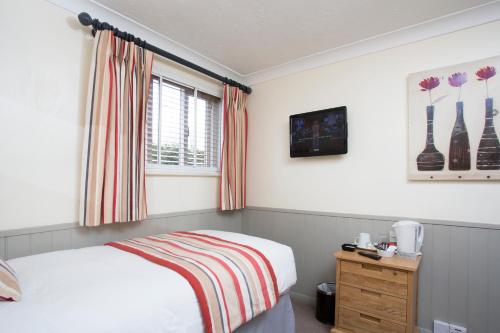 a bedroom with a bed and a window at Breckland Lodge in Attleborough