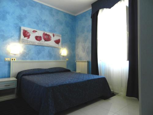 a blue bedroom with a bed and a window at Hotel Air Palace Lingotto in Turin