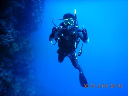 a man in a diver suit and goggles underwater at Hotel Wailiti in Maumere