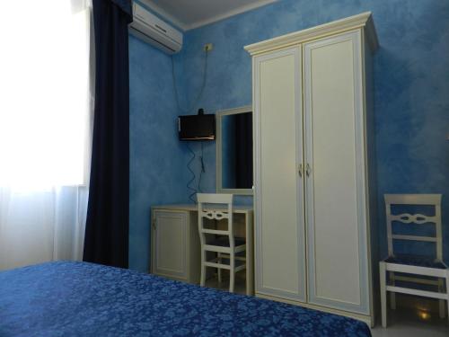 a bedroom with a bed and a cabinet and a desk at Hotel Air Palace Lingotto in Turin